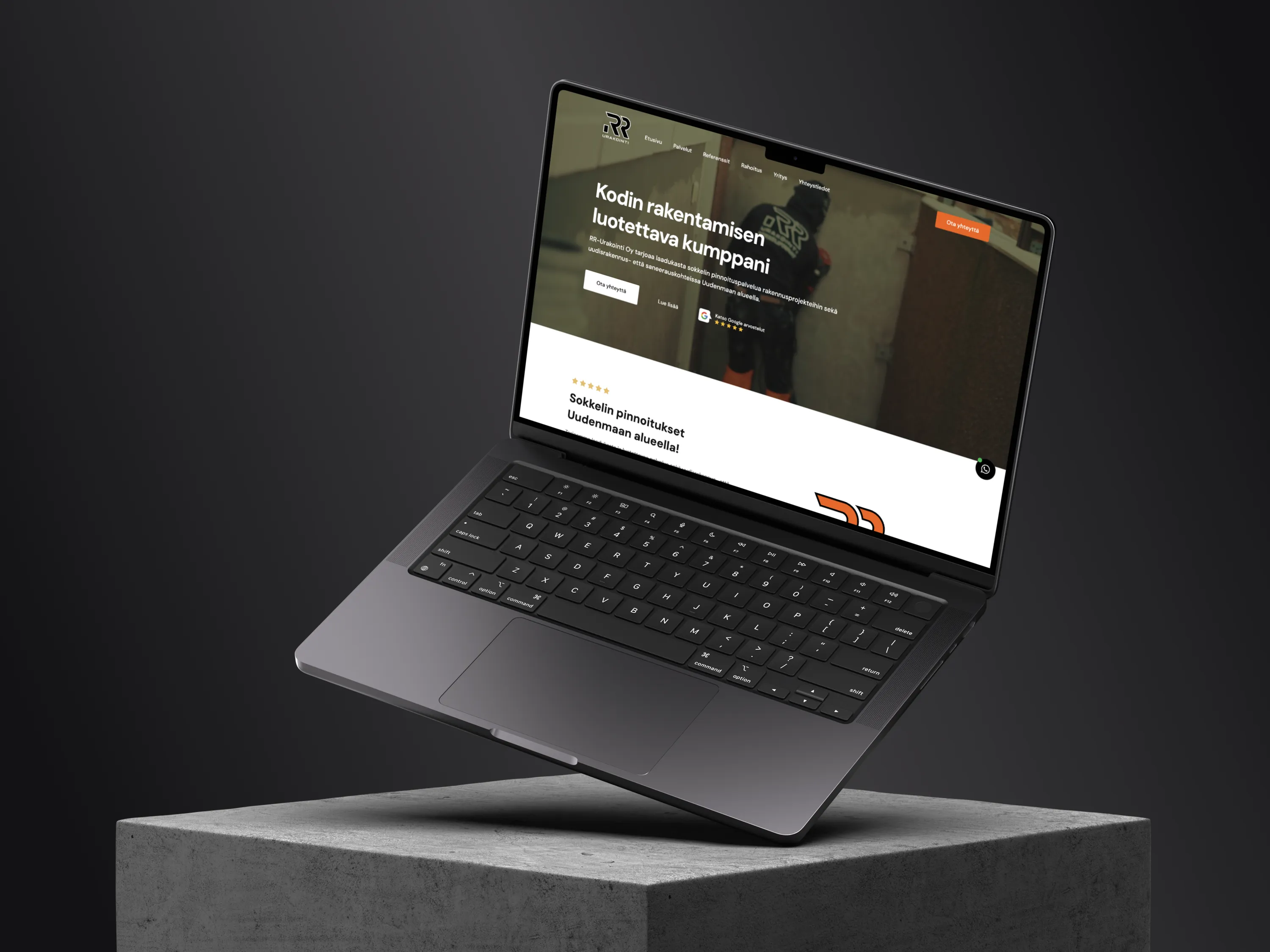 A laptop displays a construction company's website, showcasing their services on a concrete block against a dark background, with soft lighting highlighting the screen and keyboard.